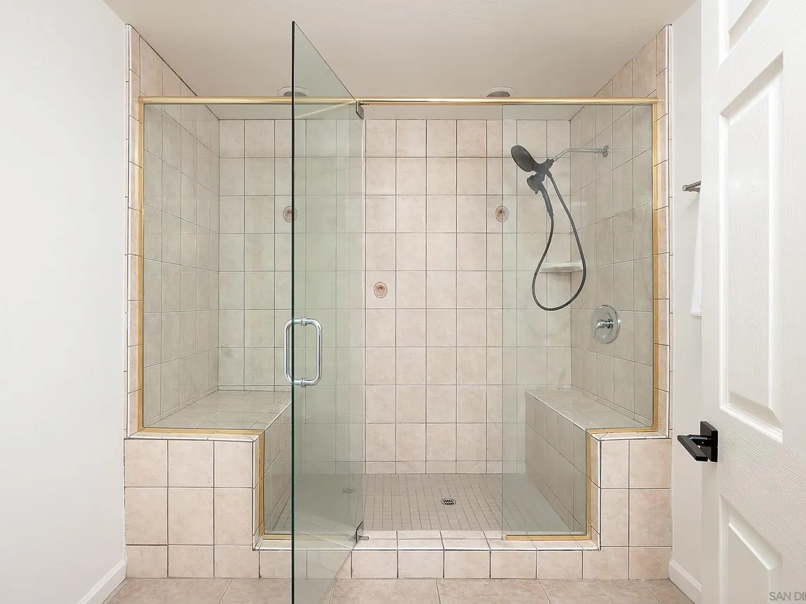 Spacious tiled walk-in shower with bench seating