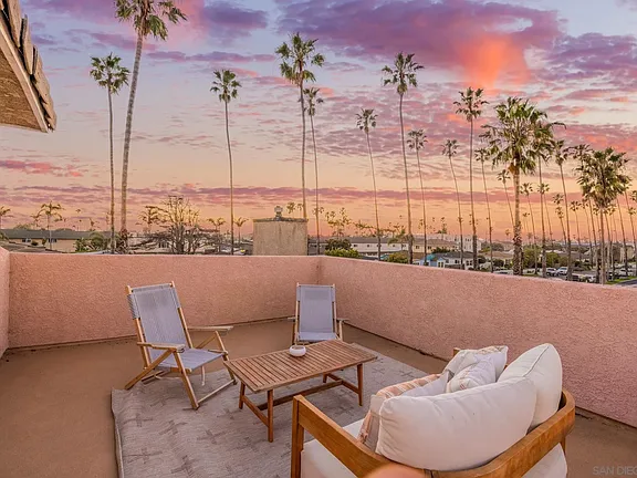 Private rooftop deck at sunset with palms