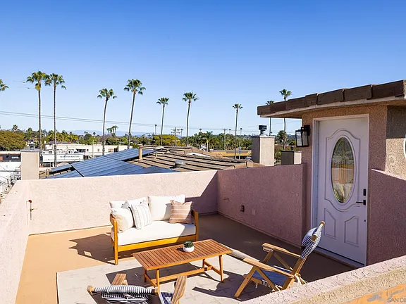 Rooftop daybed with palms and rooftop access door