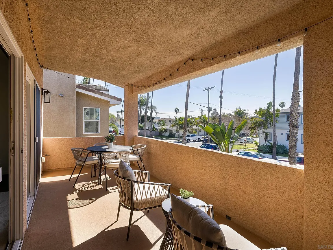 Covered balcony with woven chairs and palm views